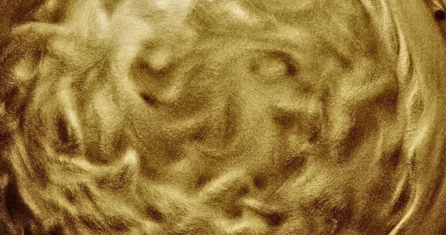 Bright shiny glittering gold ink slowly spinning in concentric waves and ripples