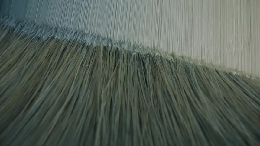 A bristle brush is used to paint a design on a surface