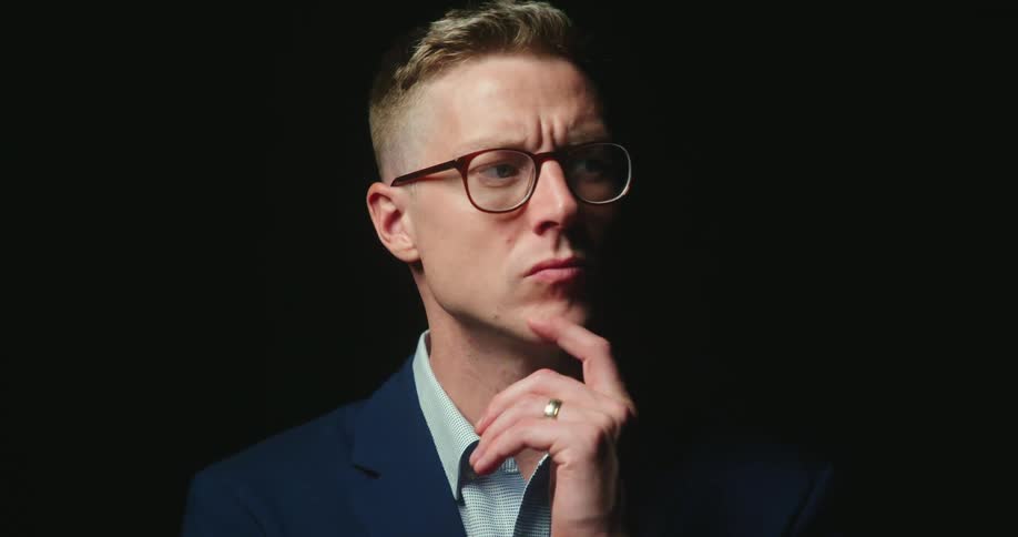 A man rubs his chin and looks side to side as he contemplates