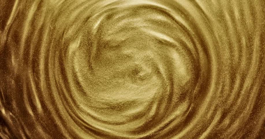 Bright shiny glittering gold ink slowly spinning in concentric waves and ripples