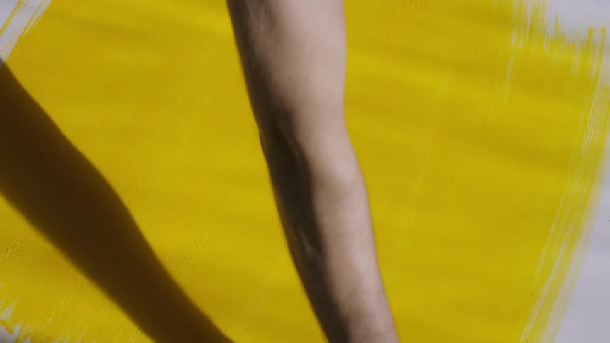Person paints white surface yellow