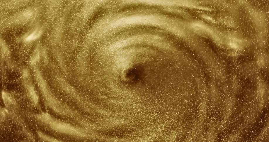 Golden glitter swirls around in a spiral as if forming a whirlpool of glitter