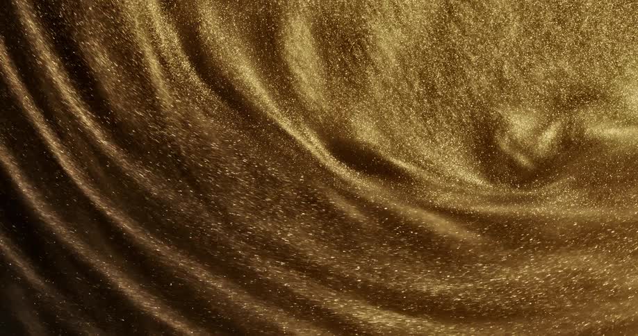 Goldishbrown glittery liquid swirls around in slow motion at a highly magnified distance