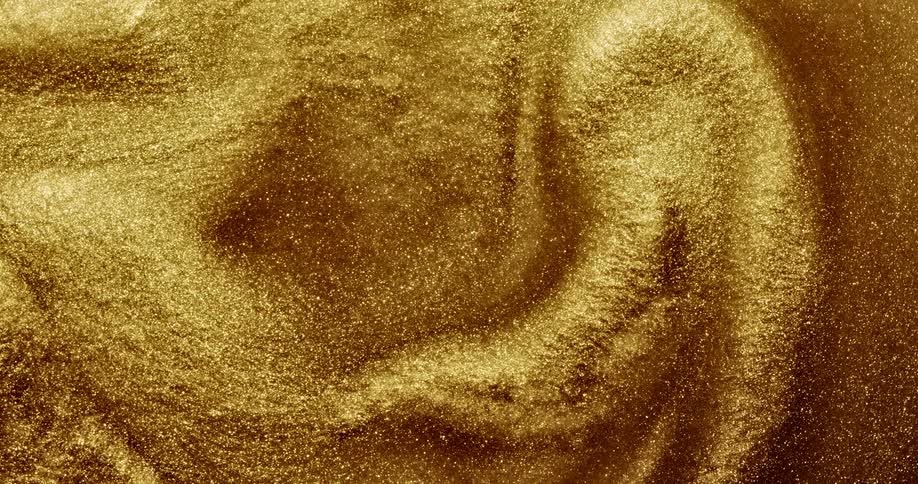 Bright shiny glittering gold ink slowly spinning in concentric waves and ripples