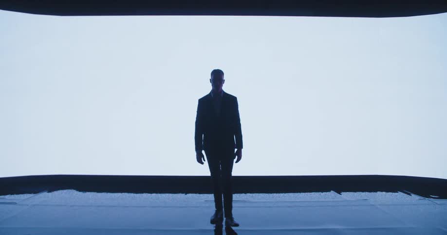 A man slowly walks towards the camera as automatic doors open for him