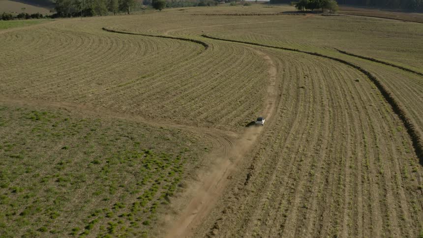 A vehicle drives across a field