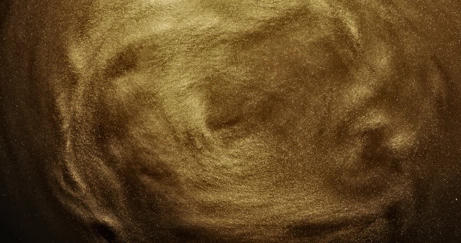 Bright shiny glittering gold ink slowly spinning in concentric waves and ripples