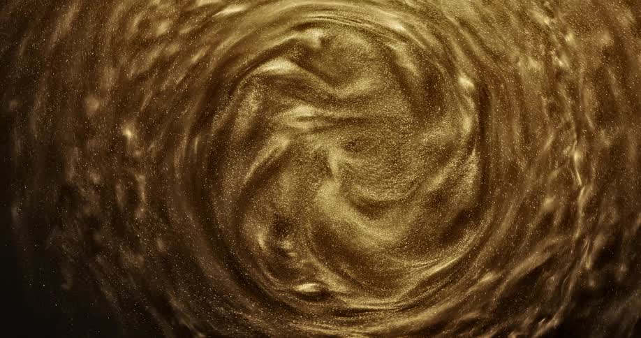 Bright shiny glittering gold ink slowly spinning in concentric waves and ripples