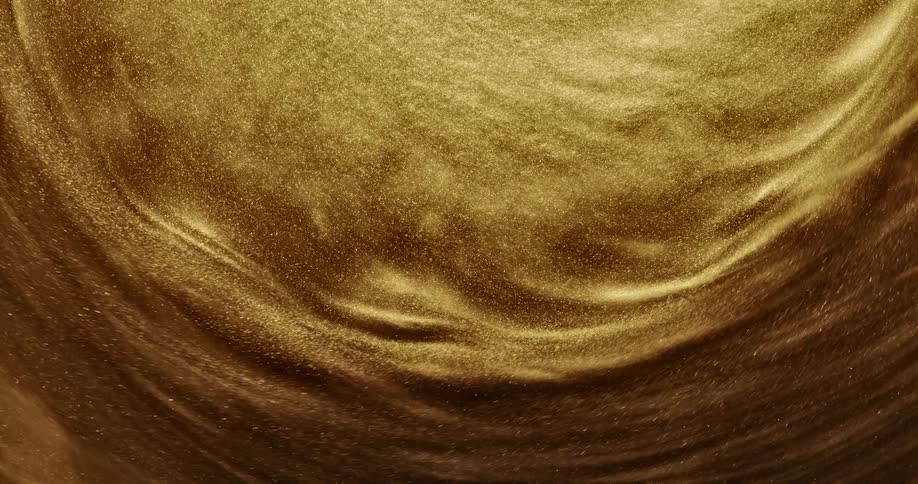 Gold liquid glitter is very close up and swirls around repeatedly
