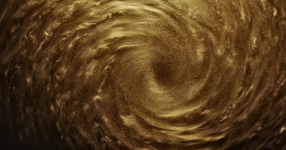 Bright shiny glittering gold ink slowly spinning in concentric waves and ripples
