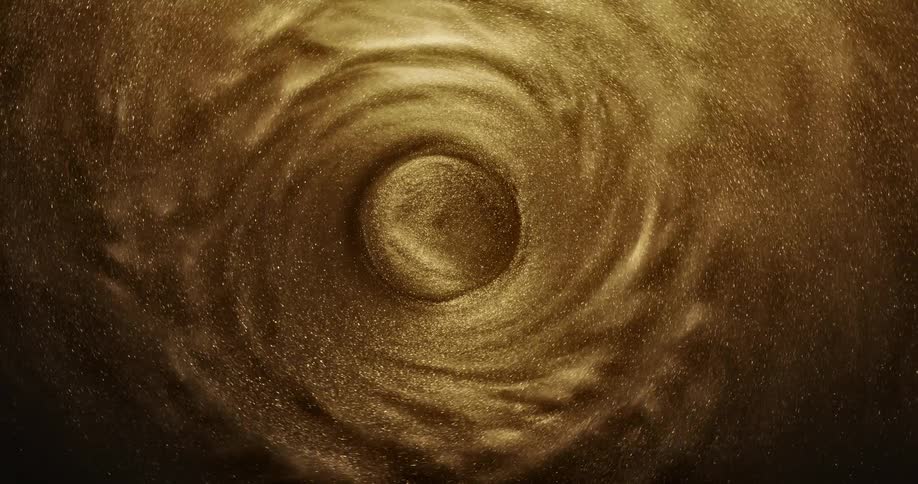 A golden liquid turns and sparkles in a swirl around a circle in the center