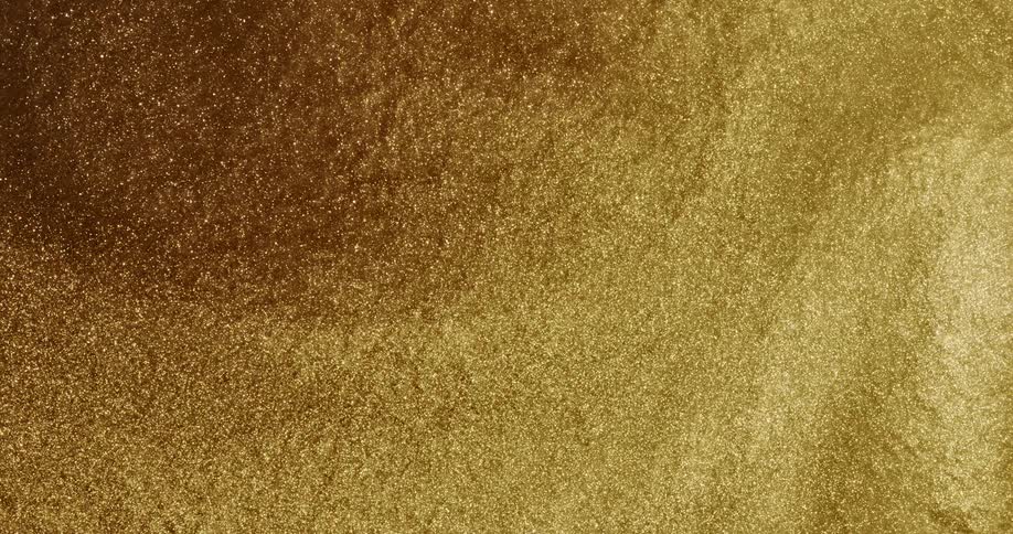 Highly magnified gold glittery liquid moves around in slow motion