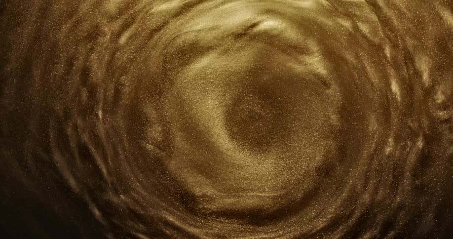 Bright shiny glittering gold ink slowly spinning in concentric waves and ripples