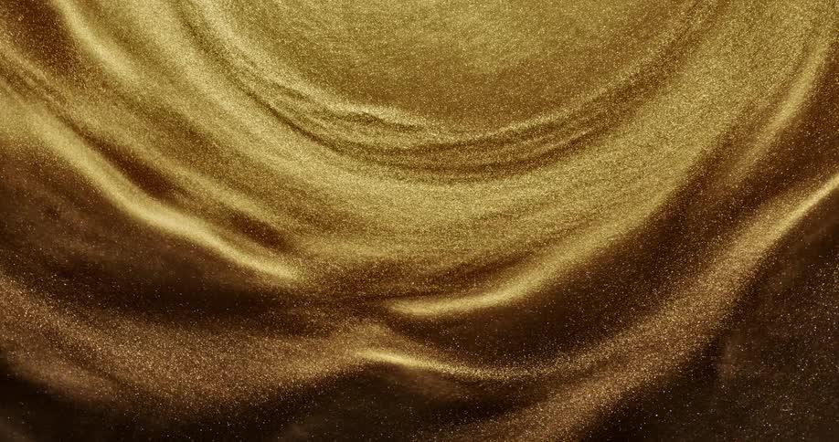 Gold glittery liquid is swirling around and shown highly magnified