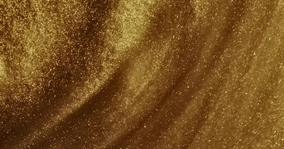 Bright shiny glittering gold ink spinning fast in concentric waves and ripples