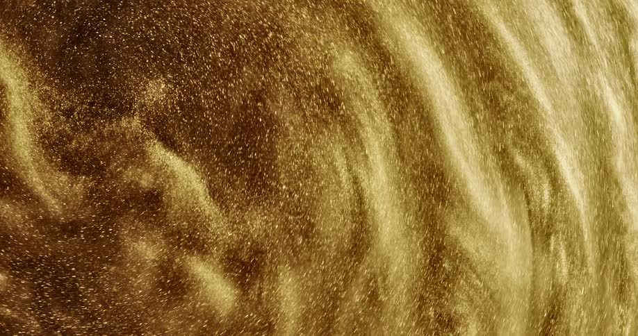 Golden grains of sand swirl and surge