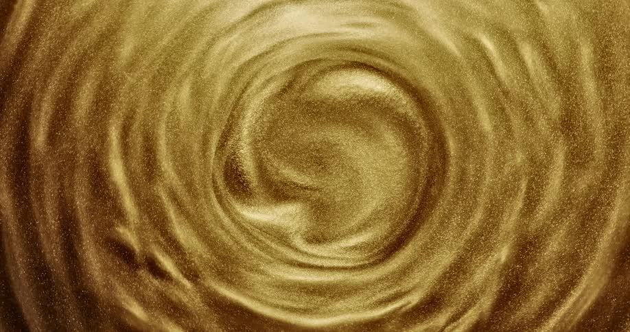 Gold sand spins around slow moving center forming swirls