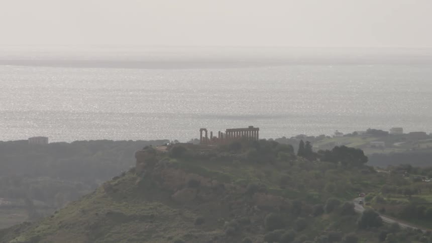 Ruins sit perched on top of a shrubby hill