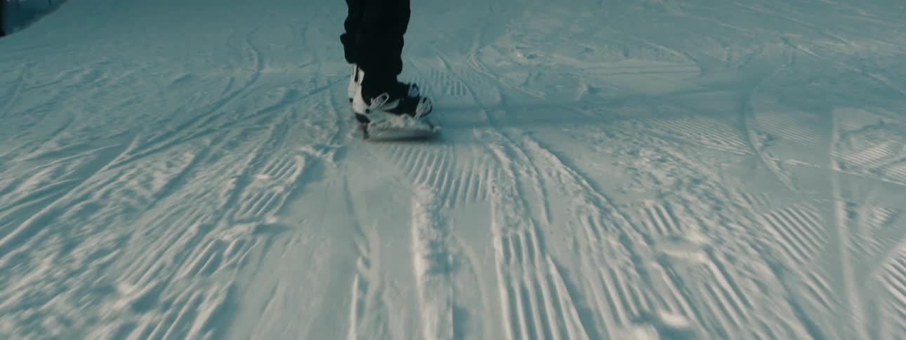 There is a man that is snowboarding in the winter in the daytime