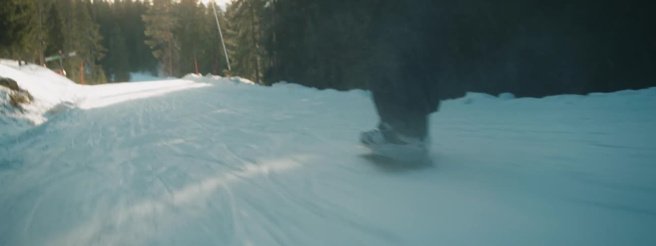 A snowboarder glides down the side of a mountain