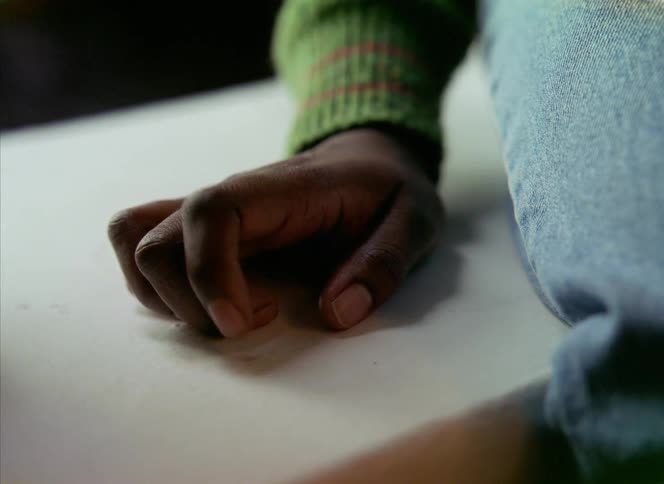 A person is sitting and tapping their finger on a surface