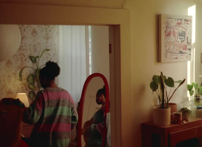A woman is trying on clothes in the mirror