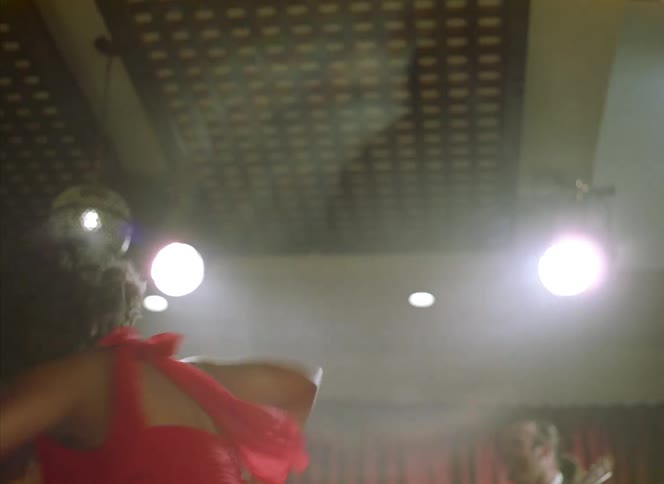 Happy young woman jumps and dances energetically to a band playing on a restaurant