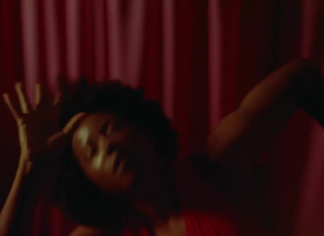 A woman swings her arms and moves her head aggressively as she dances