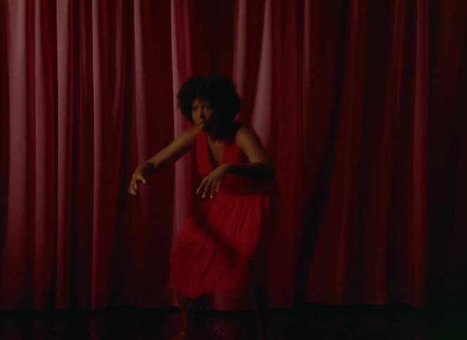 There is a black women that is dancing and moving her hands