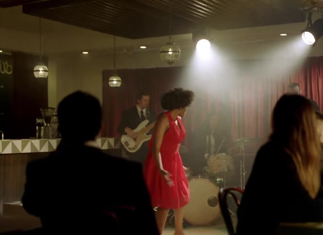 A band preforming in a club with a dancer