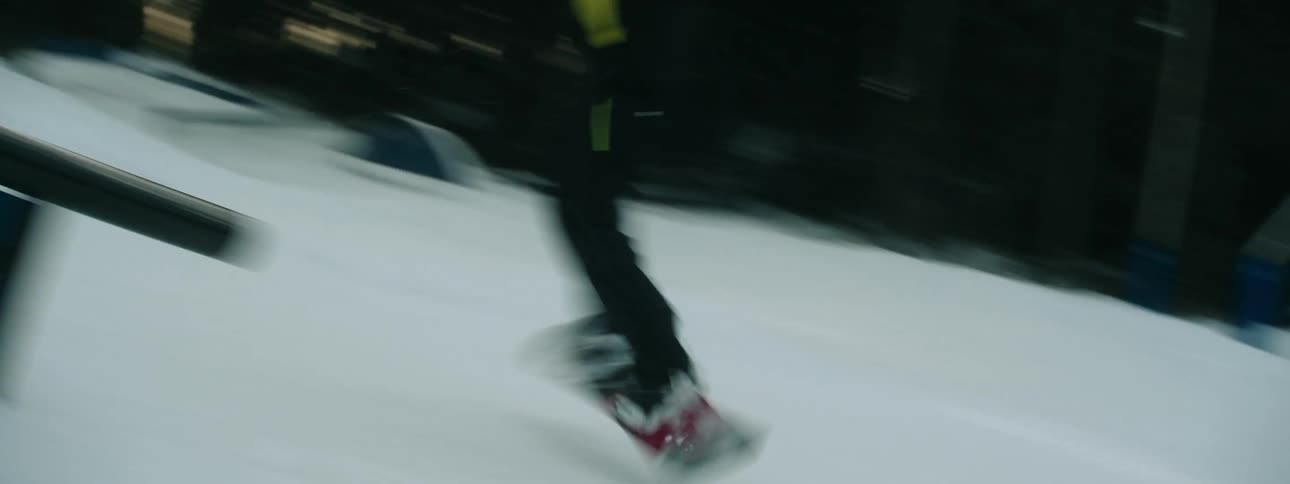 A snowboarder does a stunt spinning as he glides down a rail