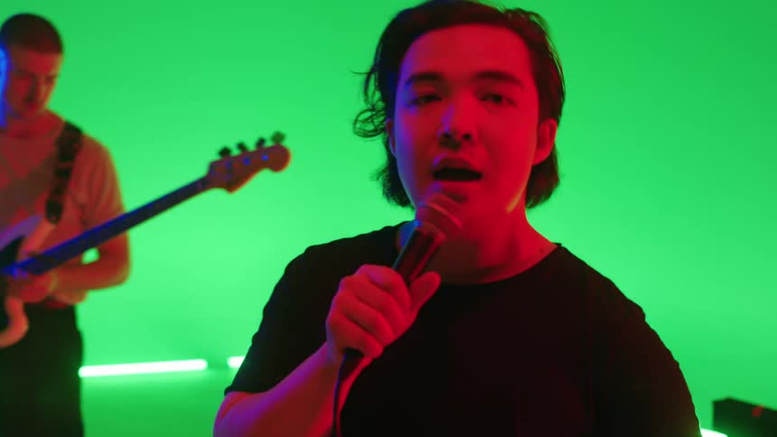 Music ban performs against green colored lighting