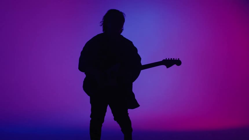 A person is dancing and holding an instrument