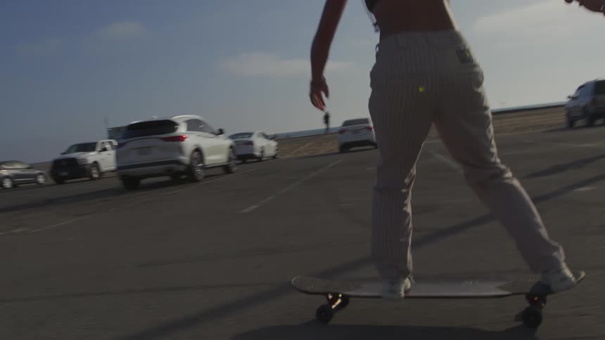 There is a women riding her skateboard in the middle of the daytime