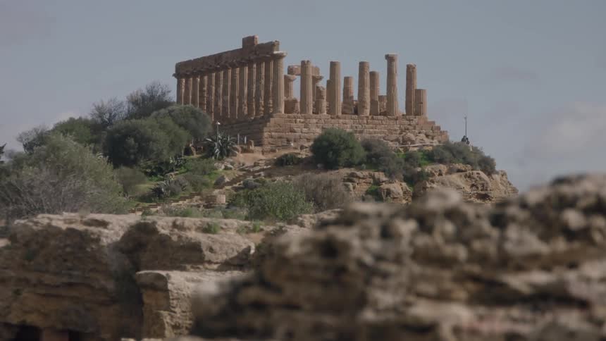Ruins sit perched on a shrubby and rocky hill