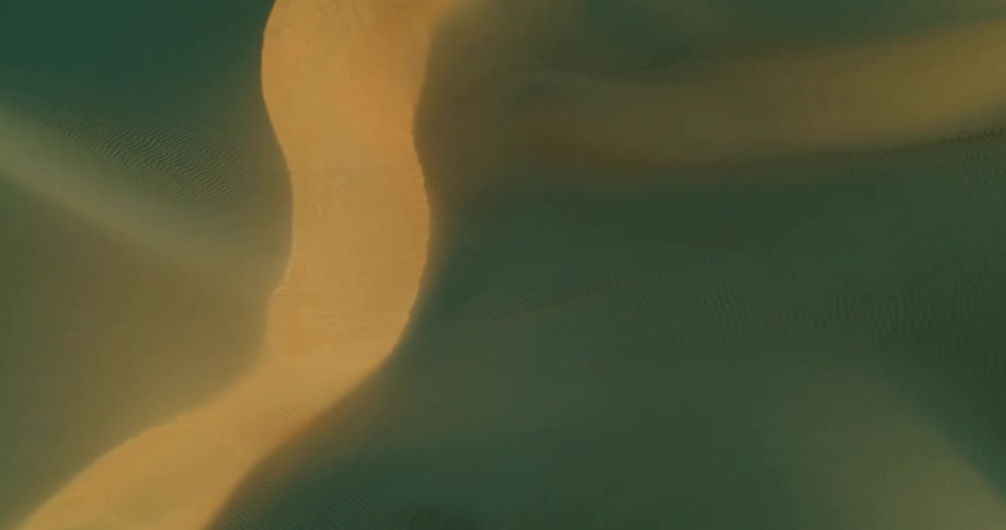 Light shines across a textured area creating greenish blue shadows along the ridge