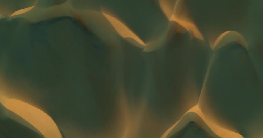 Sand dunes seen from above during sunset and dramatic golden hour lighting