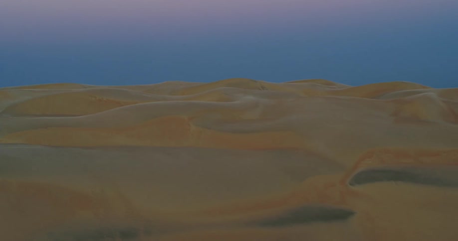 Aerial view of desert with sand dunes at dusk