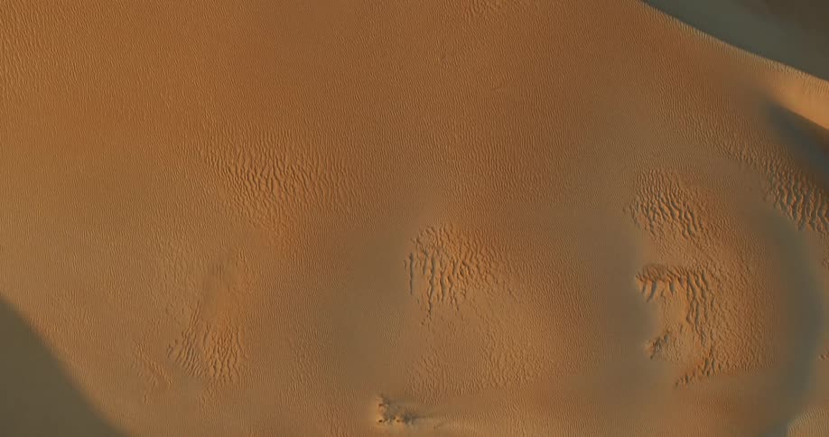 Top down aerial view of sand dunes in the desert at evening