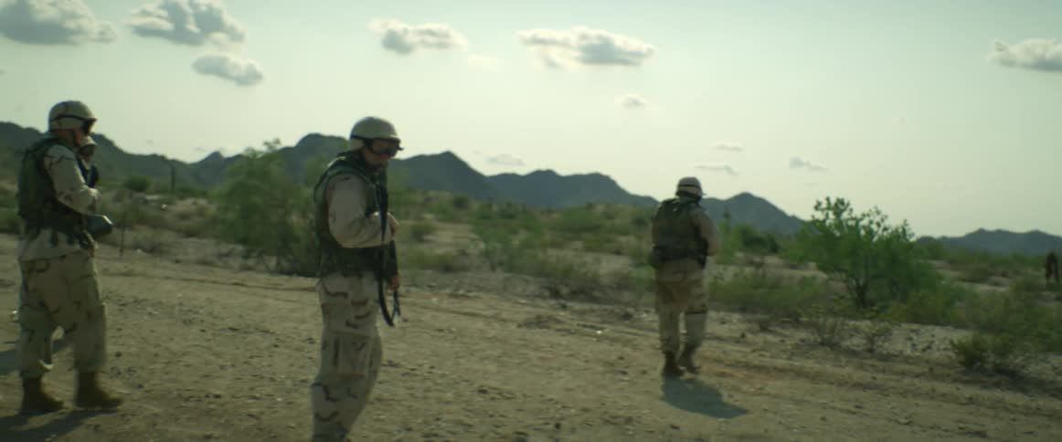 A group of soldiers with weapons and uniforms patrols and is ambushed in the field