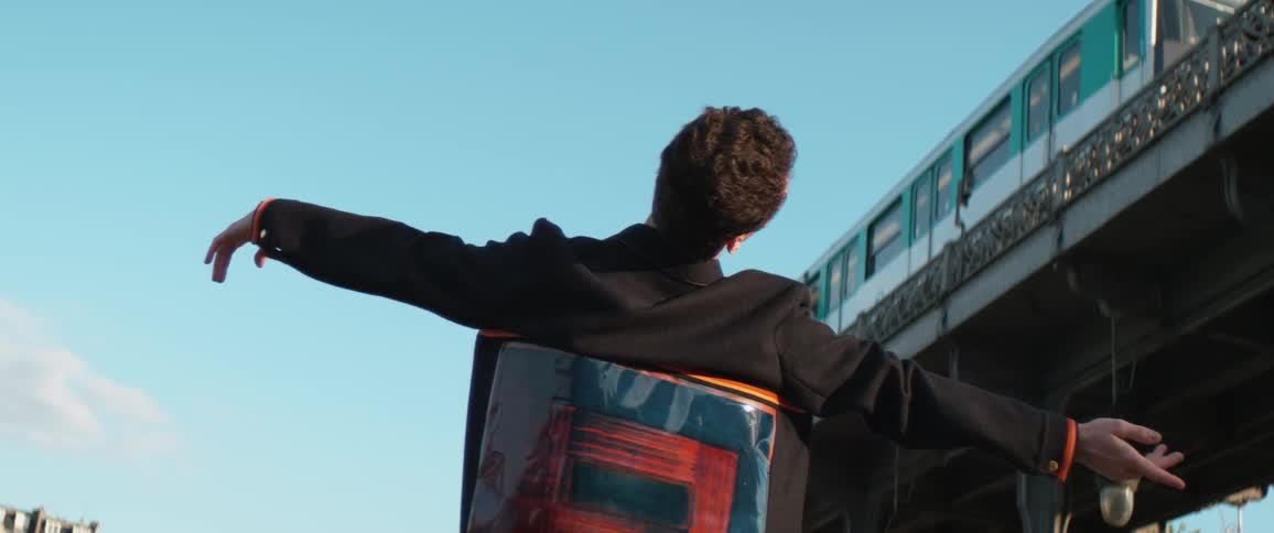 A man is stretching outdoors near a train