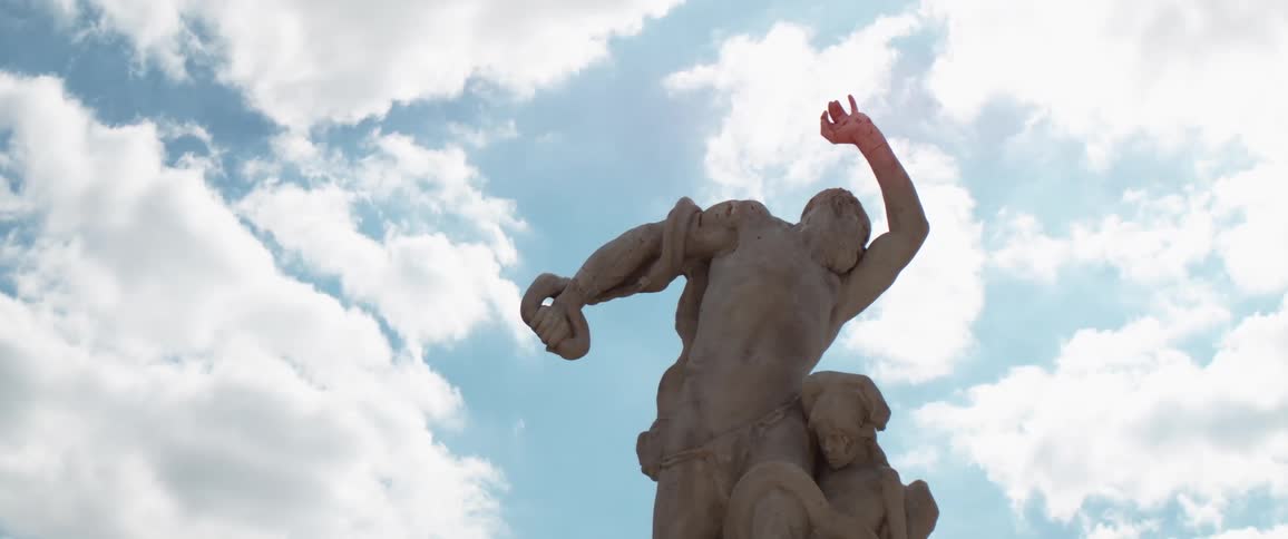 Jeanbaptiste hugues misery statue against a bright sky with fluffy white clouds