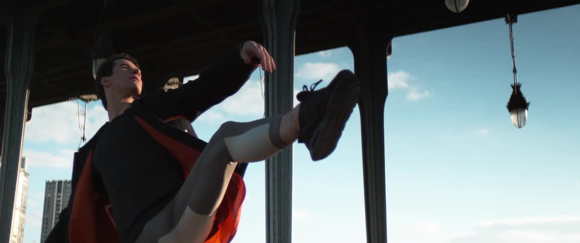 A man spins through the air while dancing in a gazebo