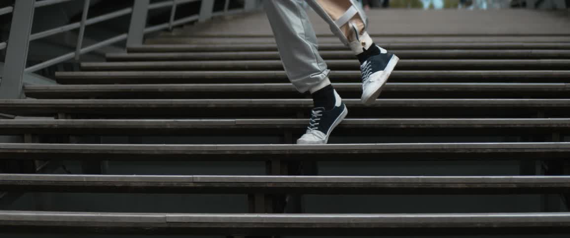 Slow motion footage of a persons feet as they walk downstairs and then turn around