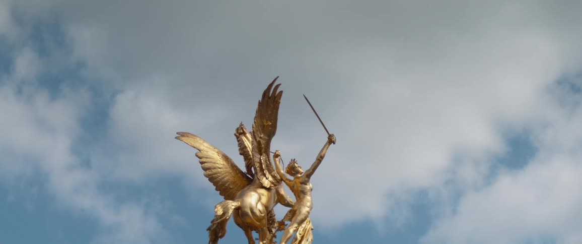Golden statue of pegasus and a woman holding sword in under a cloudy paris sky