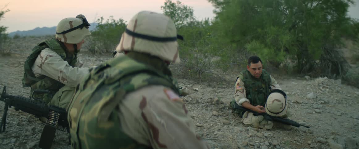 Soldiers sit and talk on land
