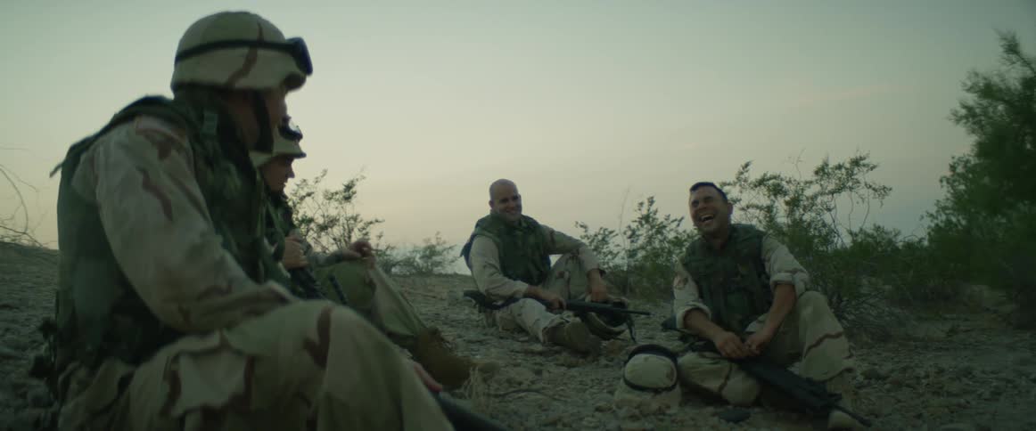 A group of military people are sitting outdoors