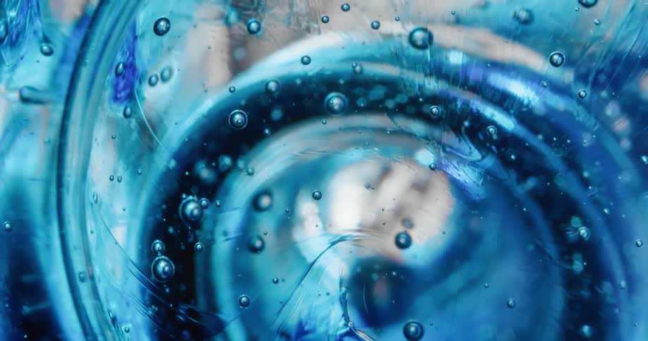 Close up of waves of thick blue translucent gel swelling and bubbling up