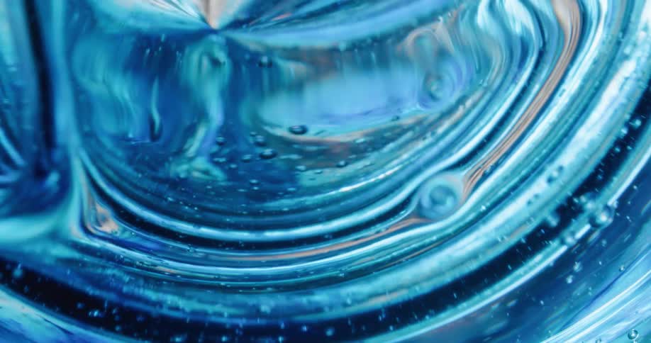 Bubbles rise to the surface as ripples move outward in a blue liquid