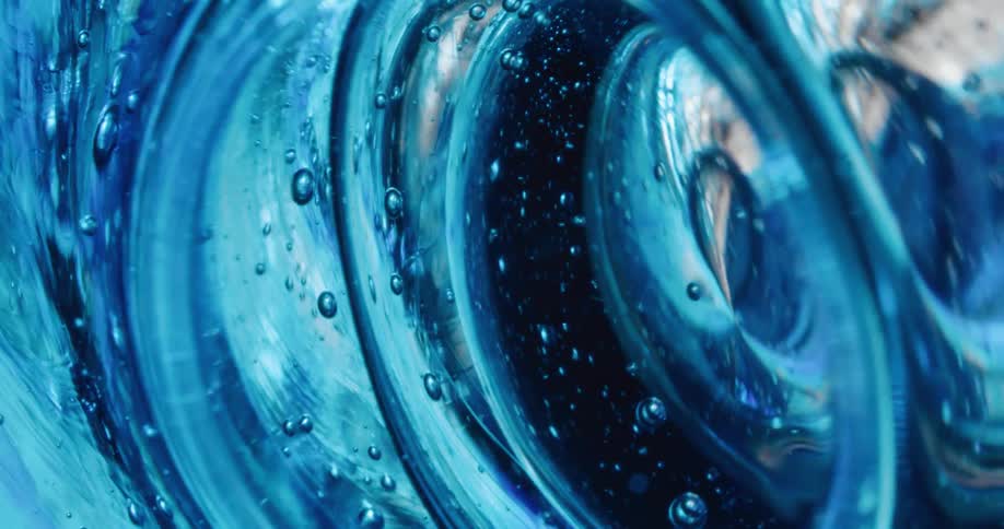 Close up of waves of thick blue translucent gel swelling and bubbling up